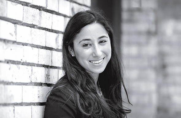 Woman leaning against wall and smiling