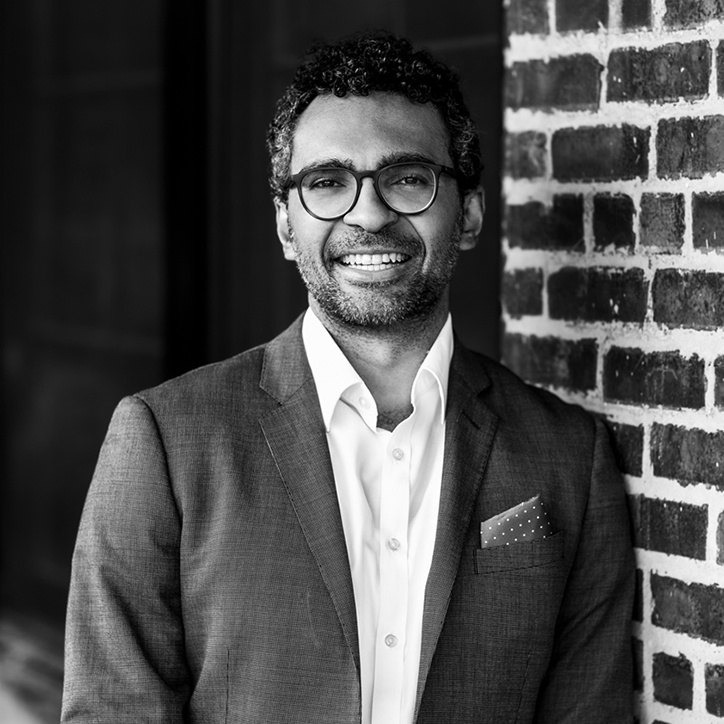 man leaning against wall and smiling